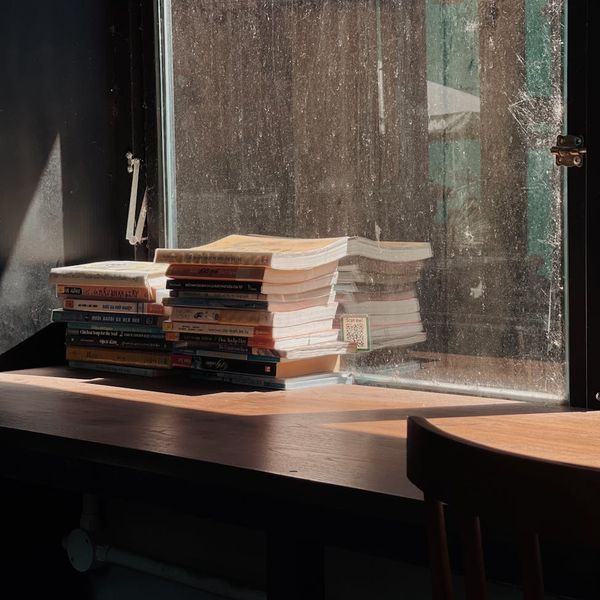 Stack of books on a wooden table in sunlight